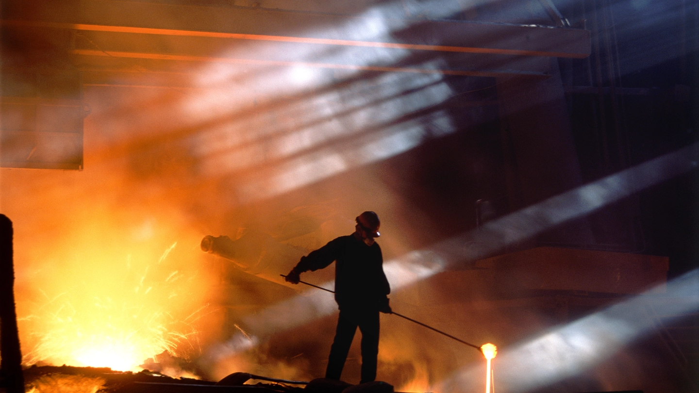 Smelting worker moving ore in landscape shot image