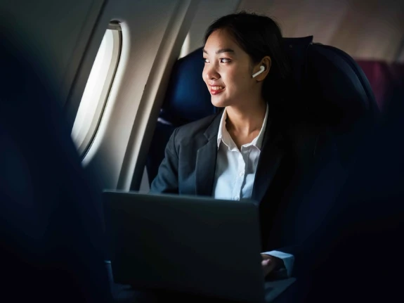 Successful Asian business woman working in airplane cabin during flight small